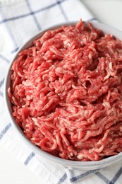 Photo of Raw ground meat in bowl on table, closeup