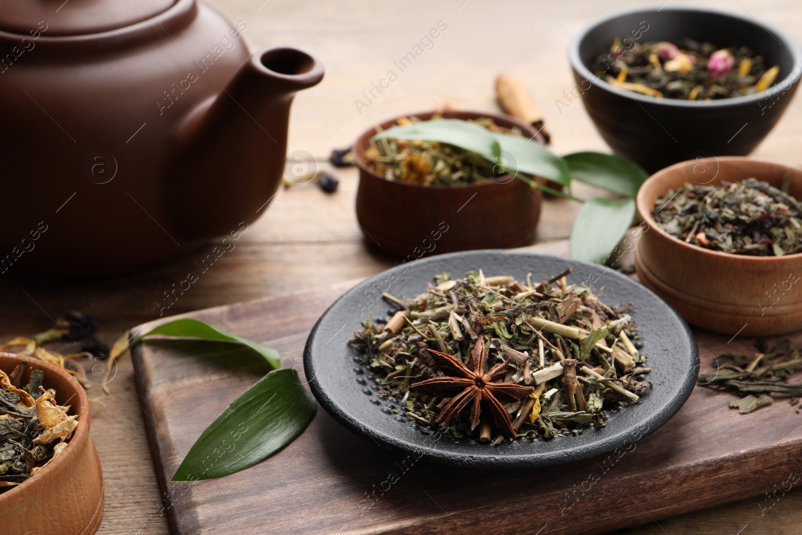 Photo of Different dry aromatic teas on wooden table