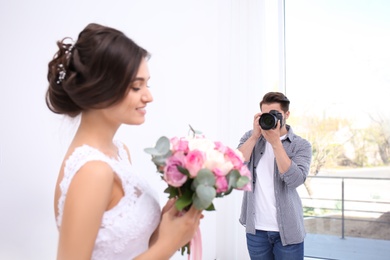 Professional photographer taking photo of wedding couple in studio