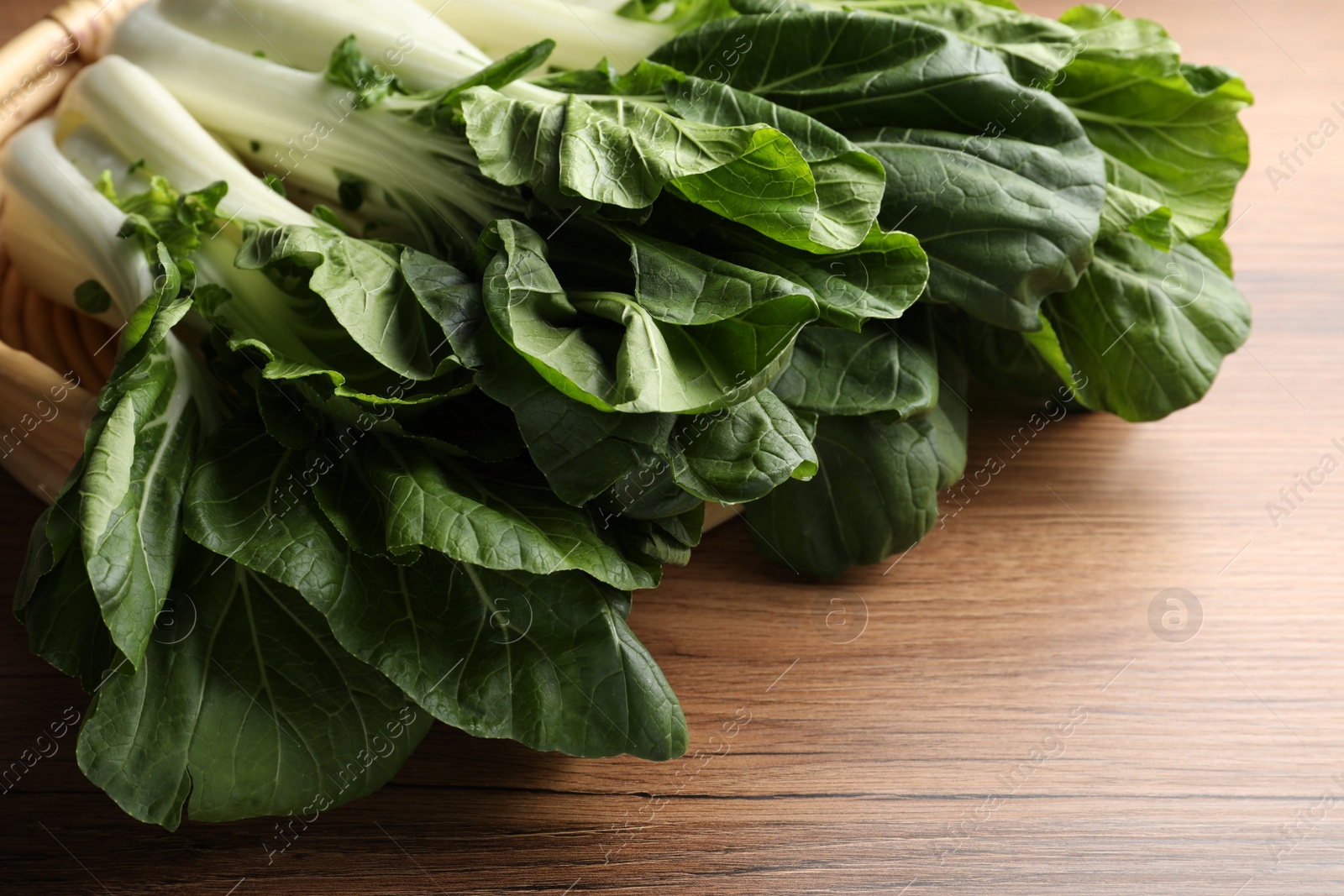 Photo of Fresh green pak choy cabbages on wooden table, closeup