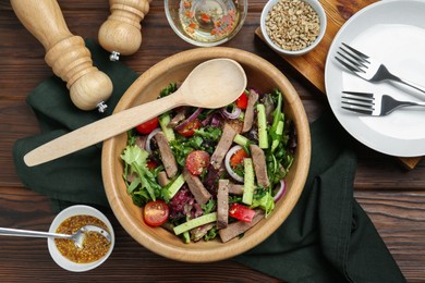 Photo of Delicious salad with beef tongue, vegetables and spoon served on wooden table, flat lay