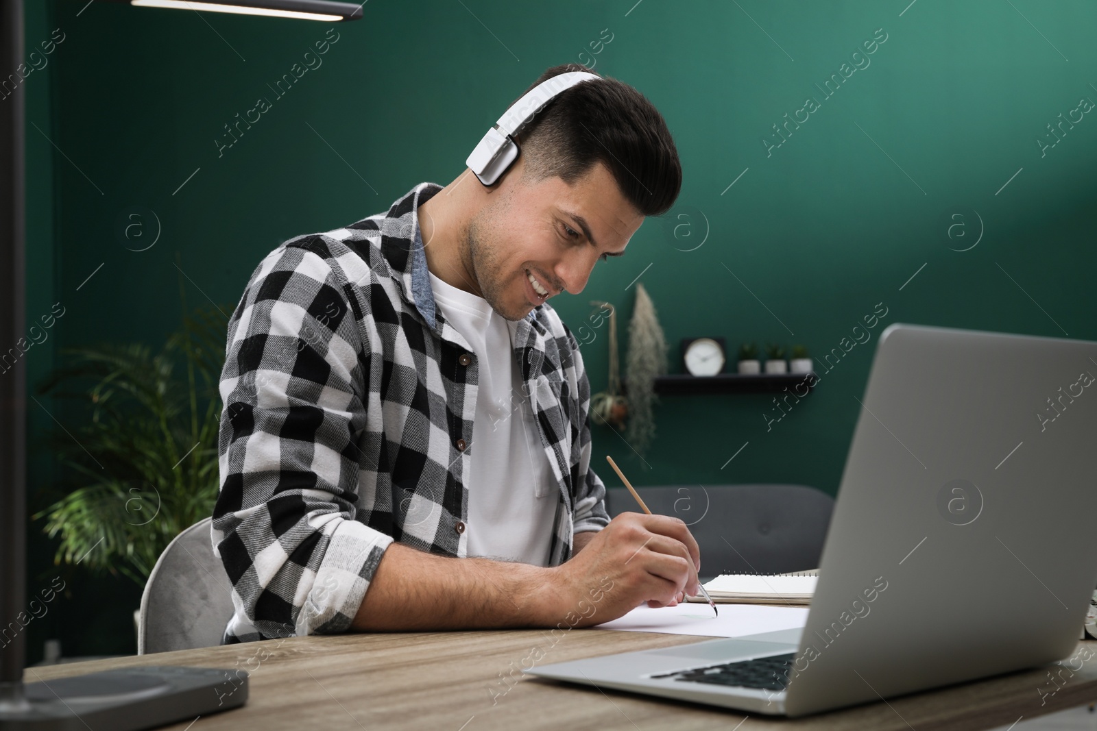 Photo of Man drawing with paints at online lesson indoors. Distance learning