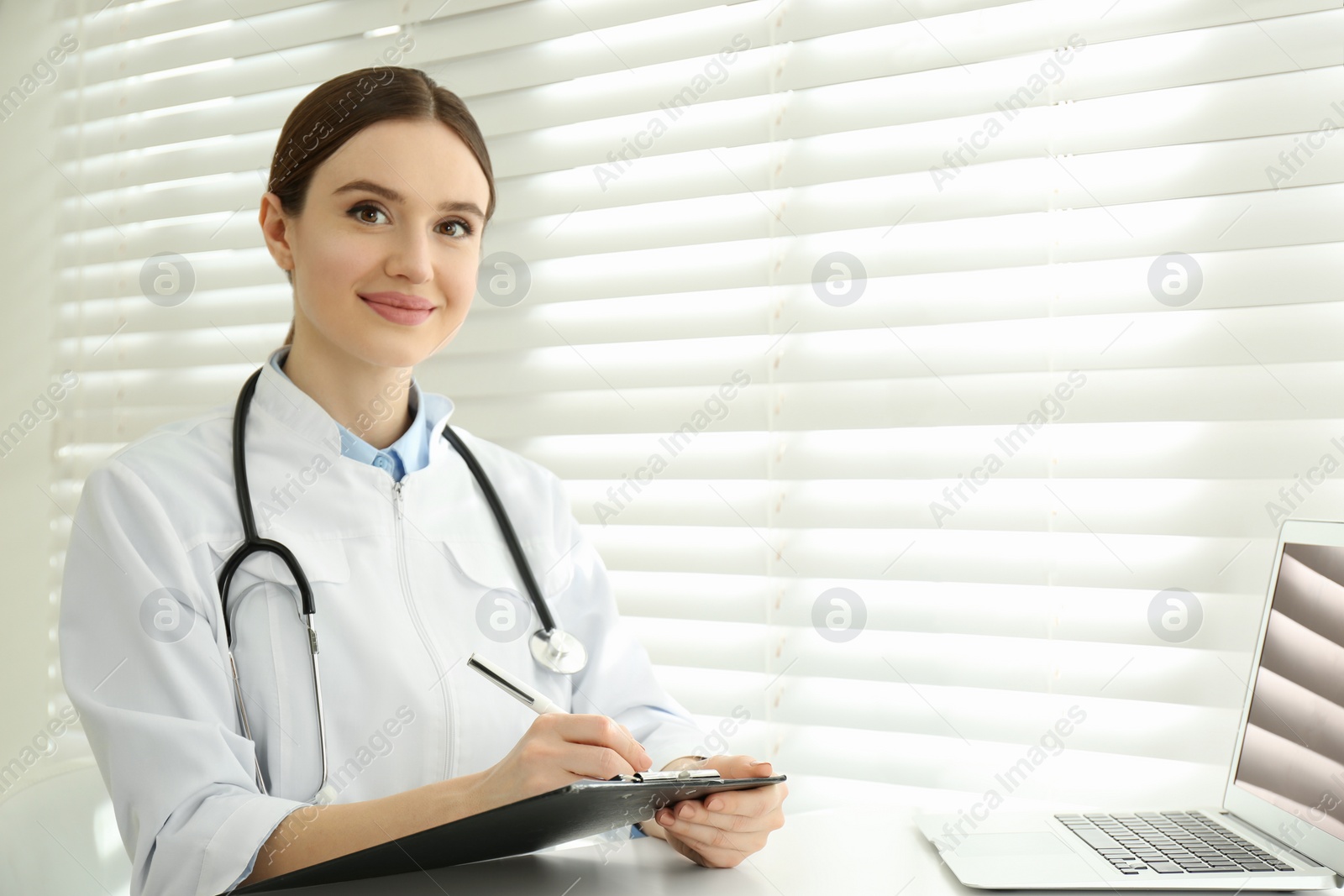 Photo of Portrait of young female doctor in white coat at workplace