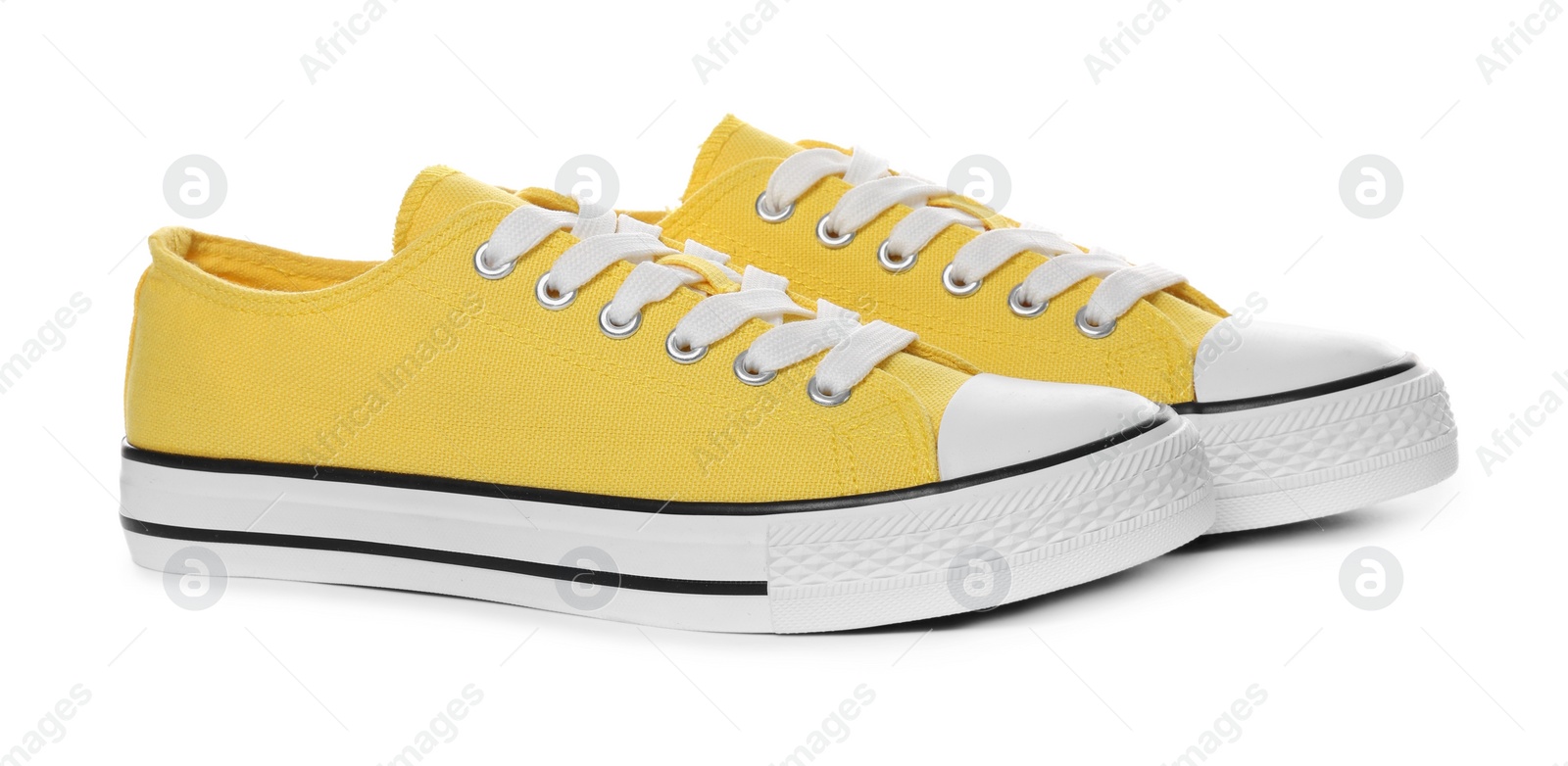 Photo of Pair of yellow classic old school sneakers on white background