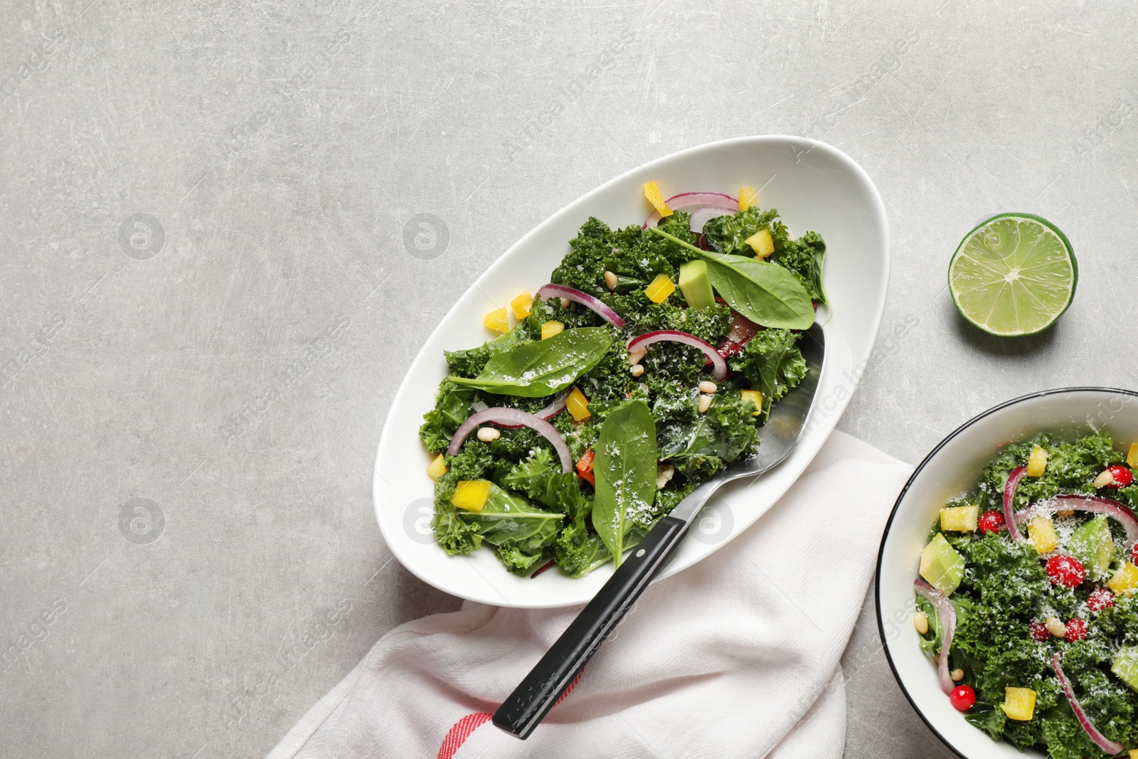 Photo of Tasty fresh kale salad on light grey table, flat lay