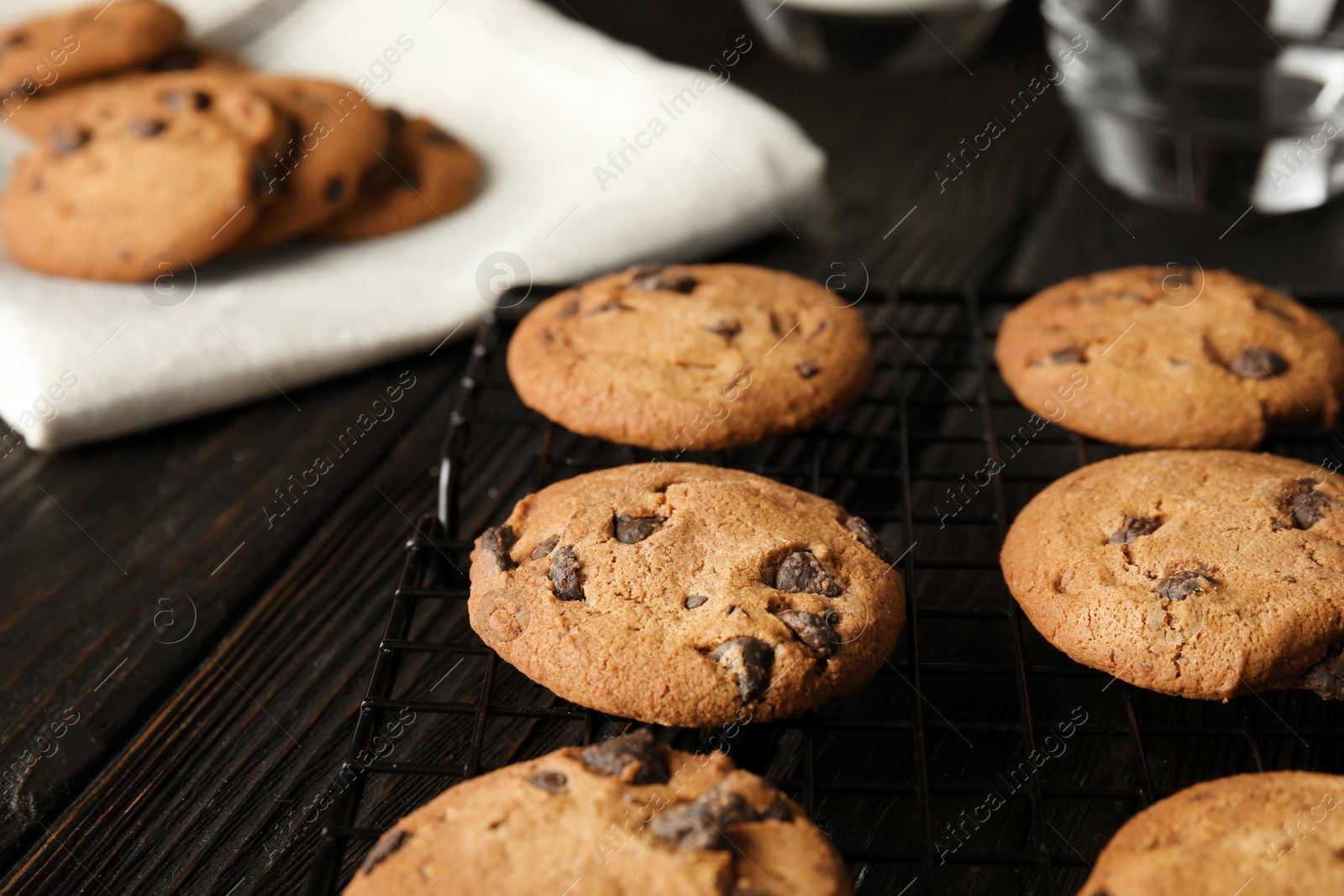 Photo of Cooling rack with chocolate chip cookies on wooden background