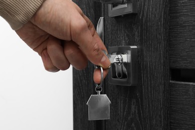 Photo of Man unlocking door with key, closeup view