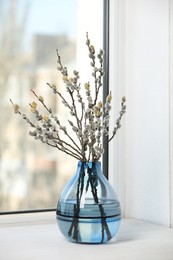 Photo of Beautiful pussy willow branches in vase on window sill