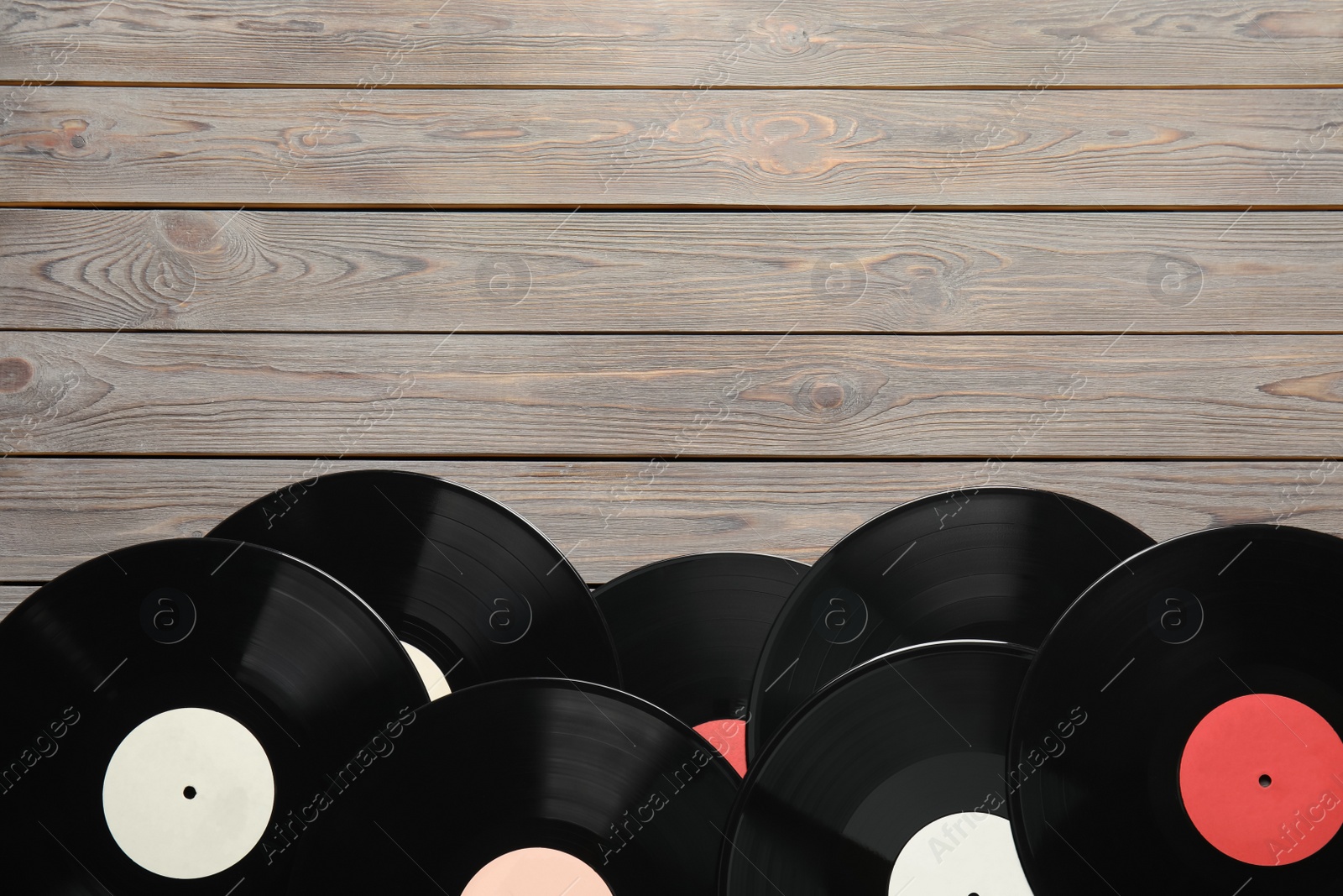 Photo of Vintage vinyl records on wooden table, flat lay. Space for text