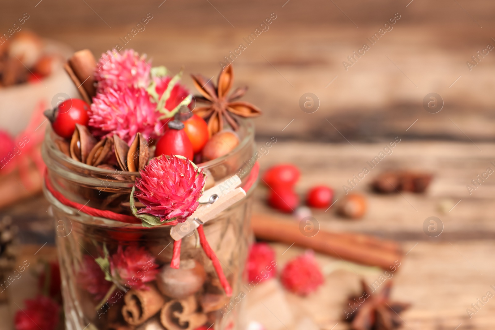 Photo of Aromatic potpourri in glass jar on table. Space for text