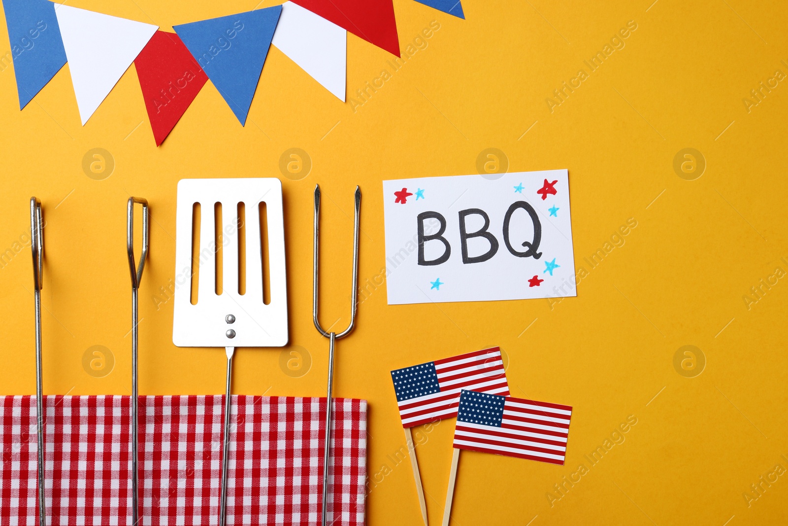 Photo of Flat lay composition with barbecue tools and card on color background. USA Independence Day