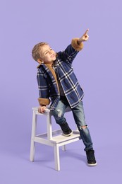 Photo of Fashion concept. Stylish boy posing on violet background