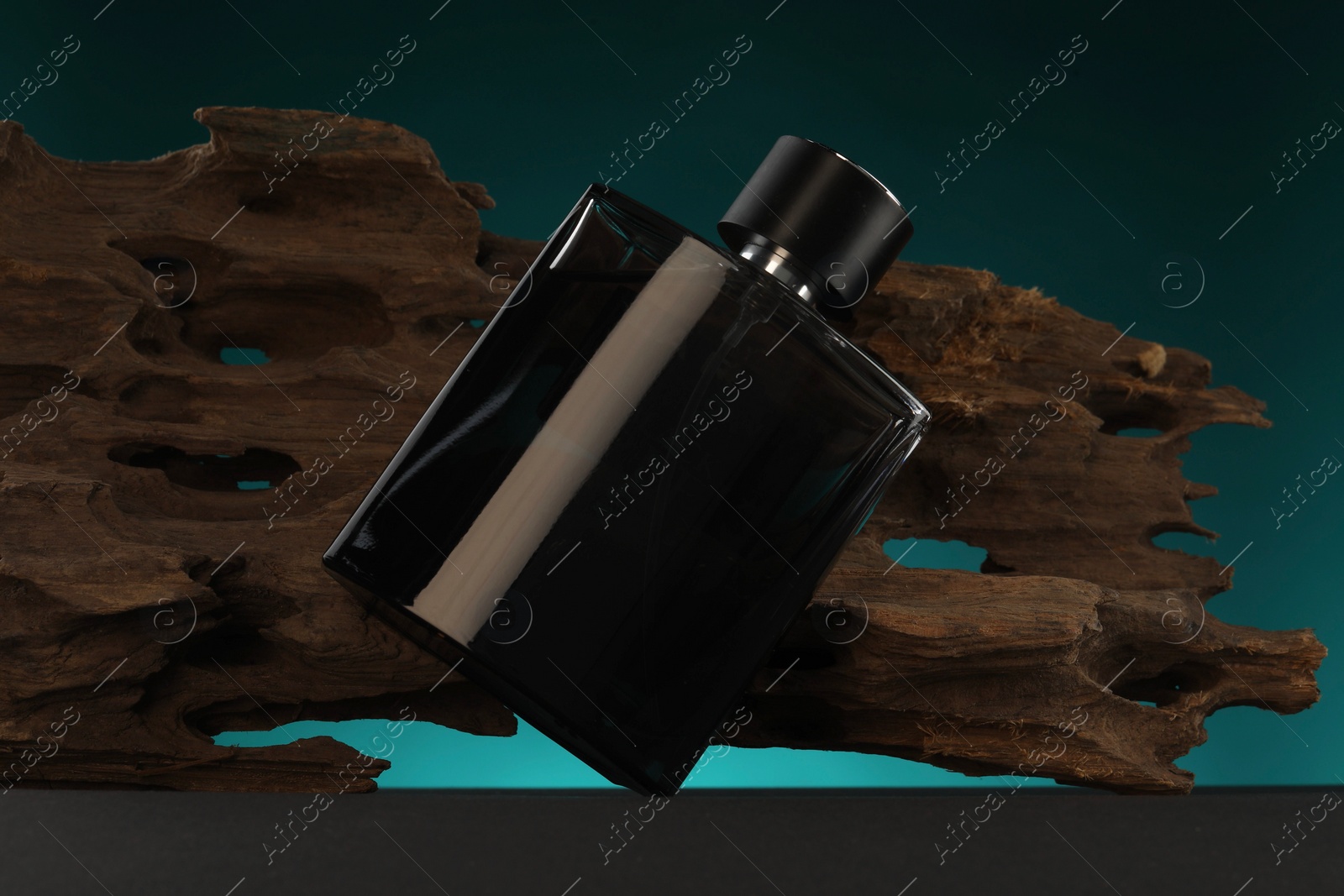 Photo of Luxury men`s perfume in bottle on grey table against color background