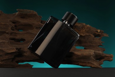 Photo of Luxury men`s perfume in bottle on grey table against color background