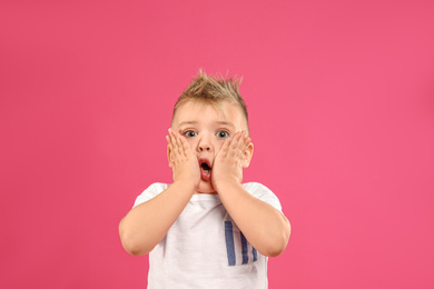 Cute little boy posing on pink background