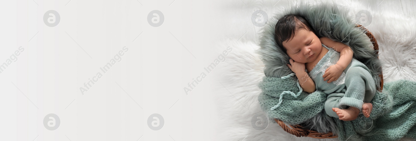 Image of Cute newborn baby sleeping in wicker basket, top view with space for text. Banner design
