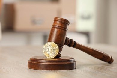 Photo of Law concept. Gavel and bitcoin on wooden table, closeup