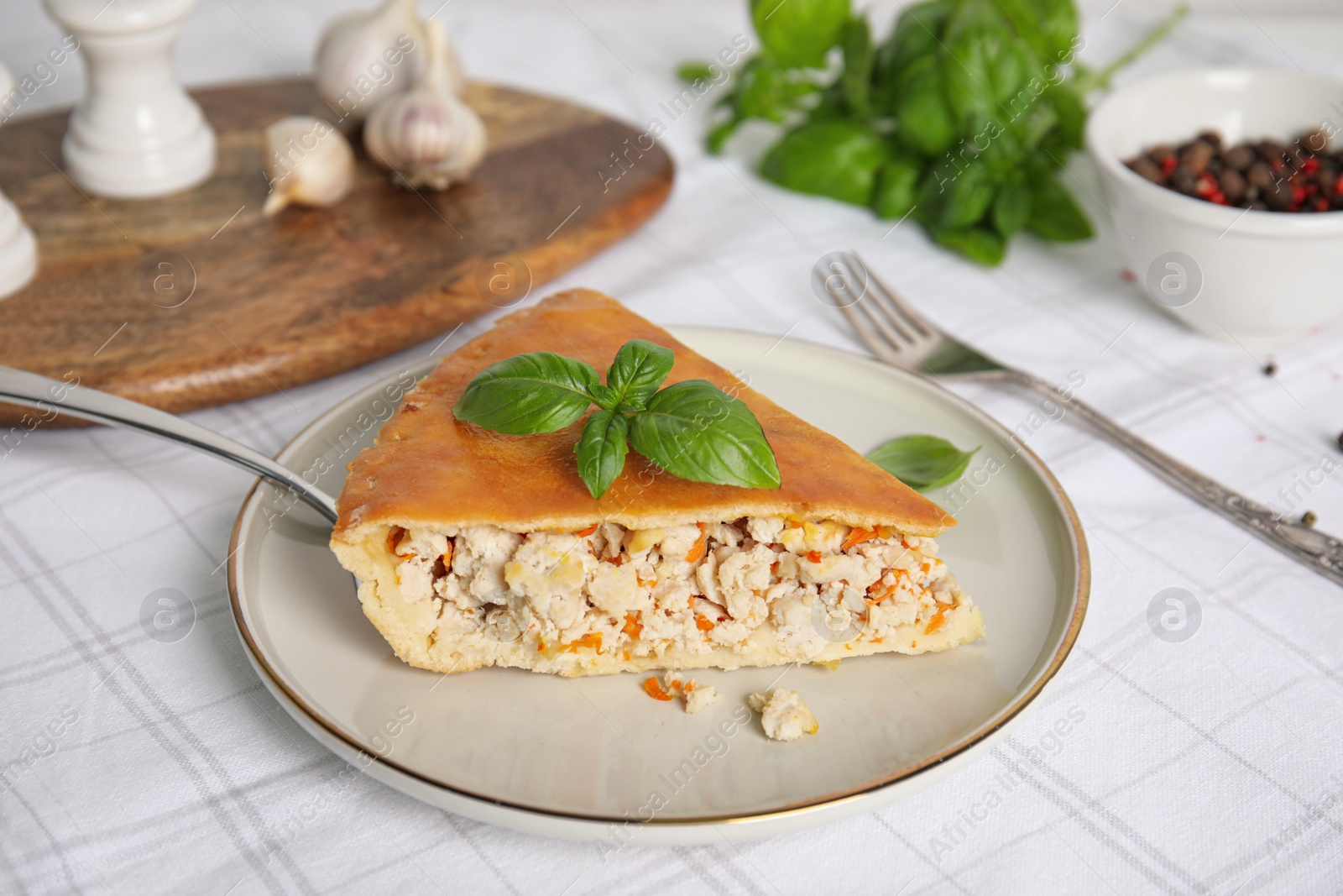 Photo of Slice of delicious meat pie with basil on table