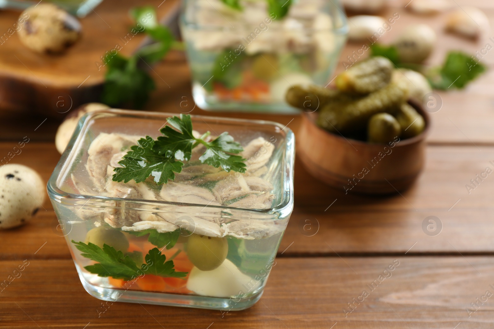 Photo of Delicious aspic with meat and vegetables served on wooden table, closeup. Space for text