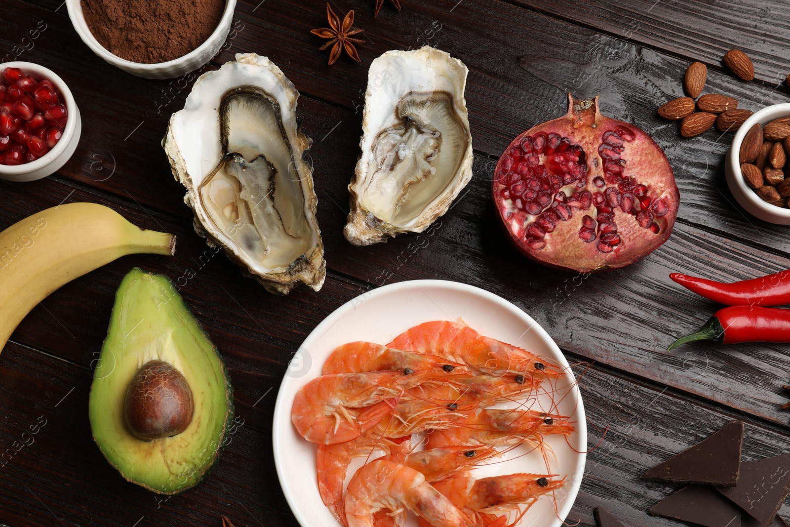 Photo of Natural aphrodisiac. Different food products on dark wooden table, flat lay