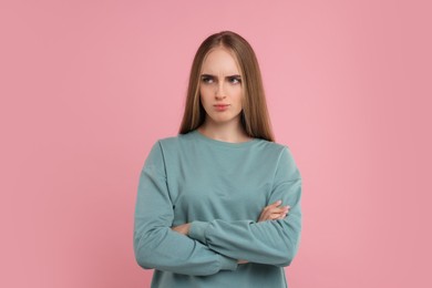 Portrait of resentful woman on pink background
