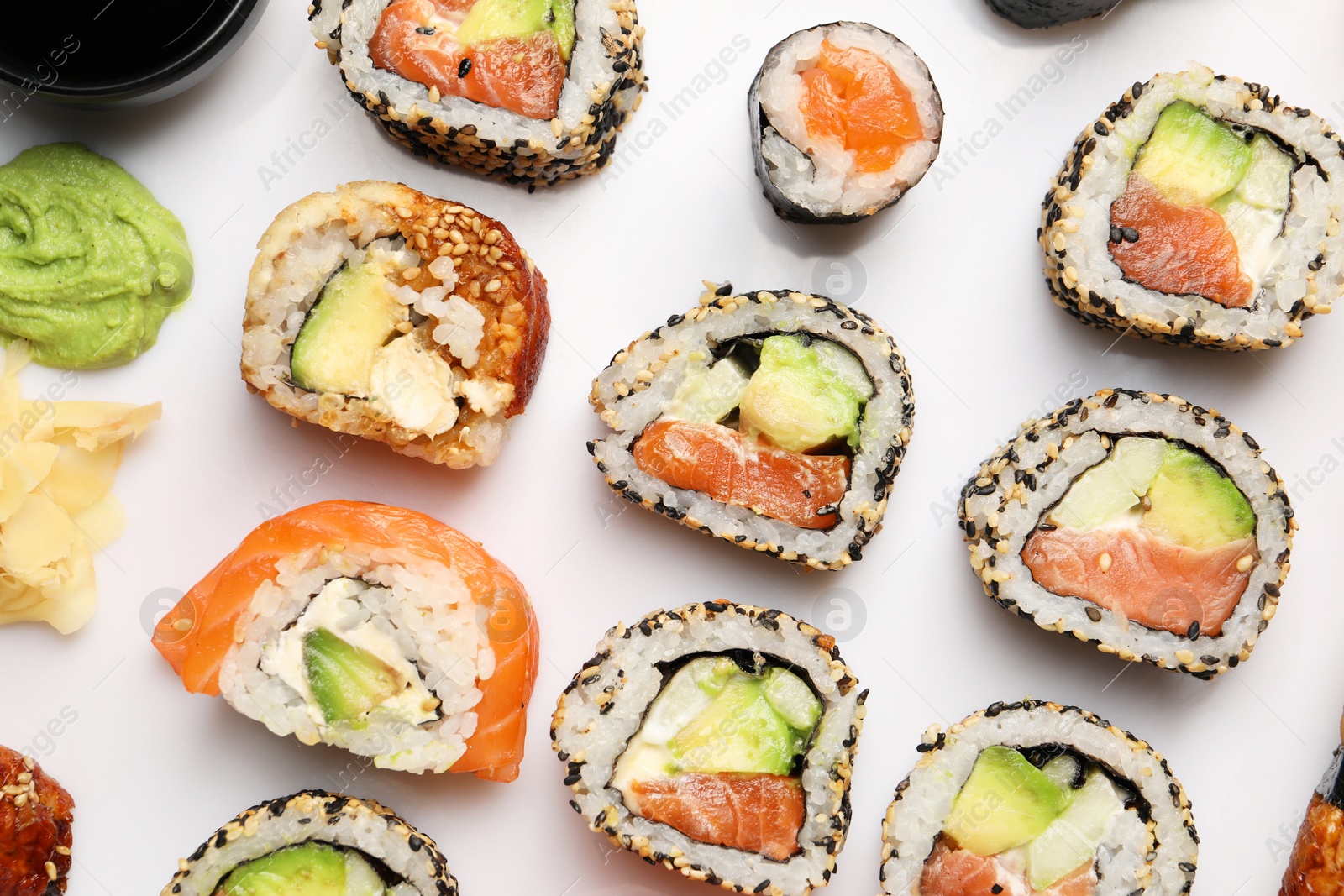 Photo of Different tasty sushi rolls on white background, flat lay