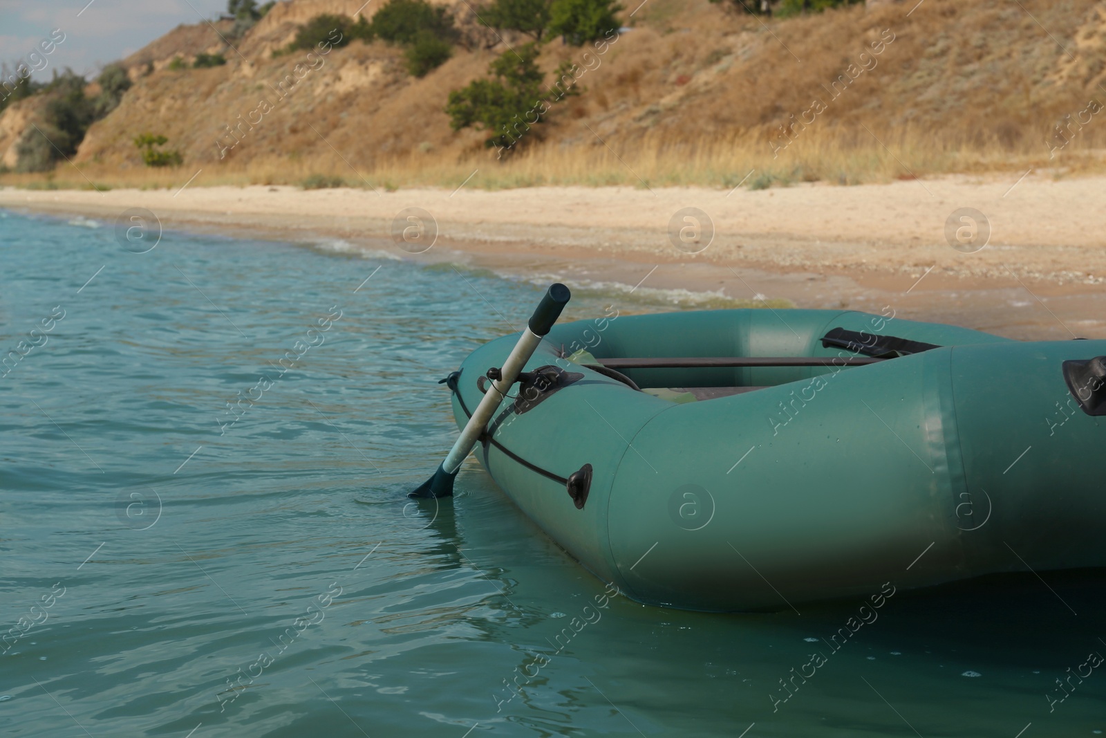 Photo of Inflatable rubber fishing boat floating in sea near coast