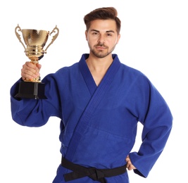 Photo of Portrait of confident young man in blue kimono with gold trophy cup on white background