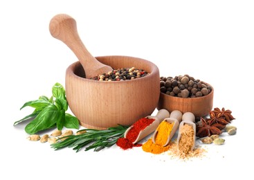 Photo of Mortar with pestle and different spices on white background