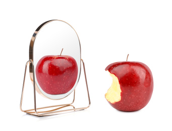 Image of Bitten red apple and mirror with reflection on white background