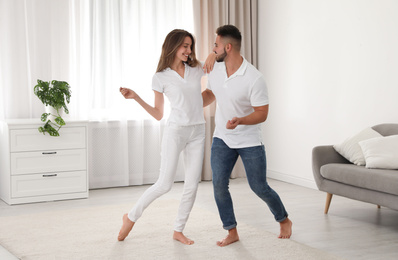 Photo of Lovely young couple dancing together at home