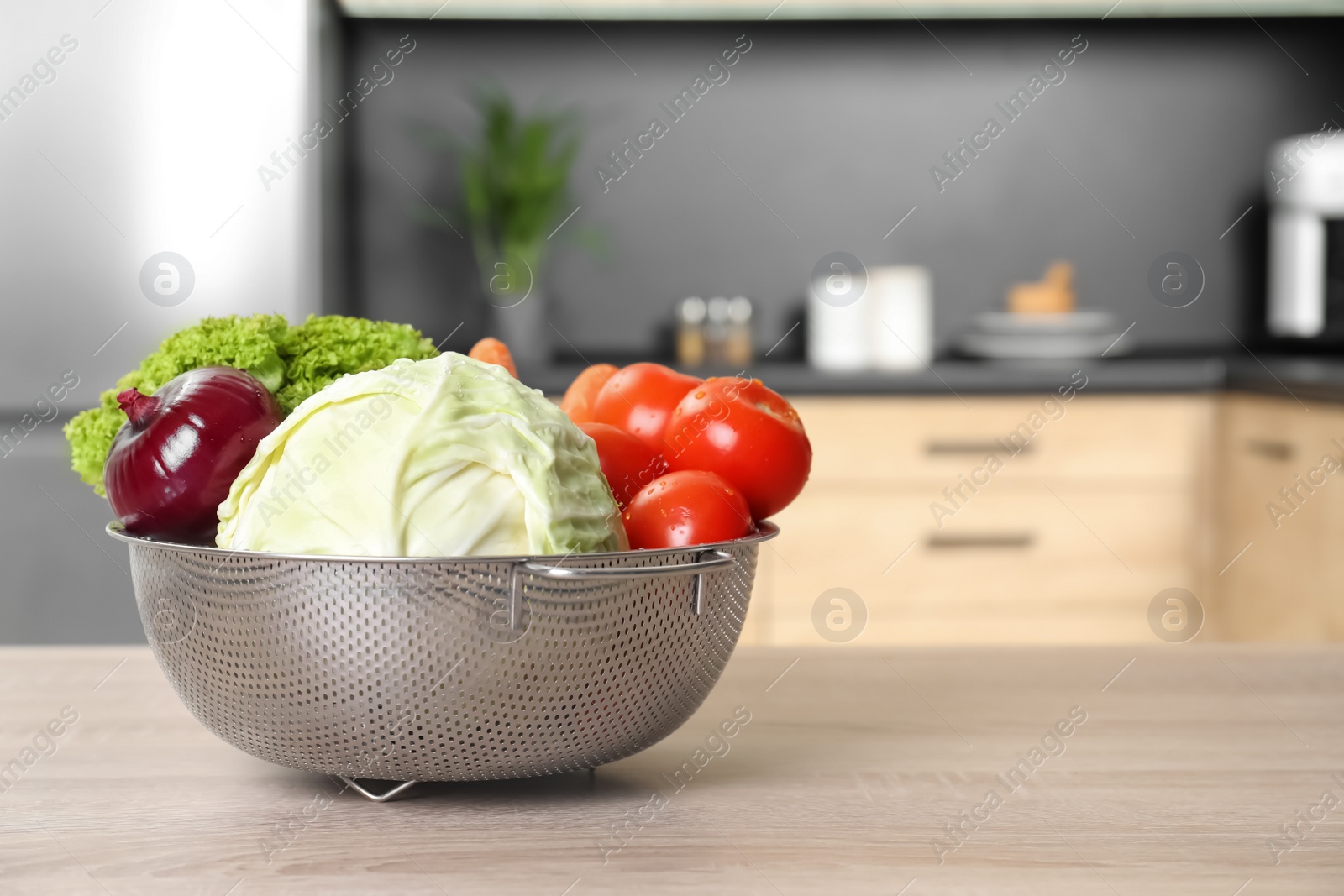 Photo of Fresh vegetables on wooden table in kitchen. Space for text