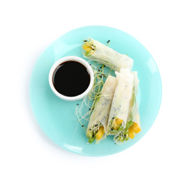 Photo of Delicious rolls wrapped in rice paper and soy sauce on white background, top view