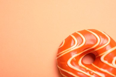 Delicious glazed donut on orange background, top view. Space for text