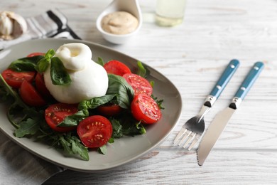 Photo of Delicious burrata cheese served with tomatoes and basil on white wooden table, closeup