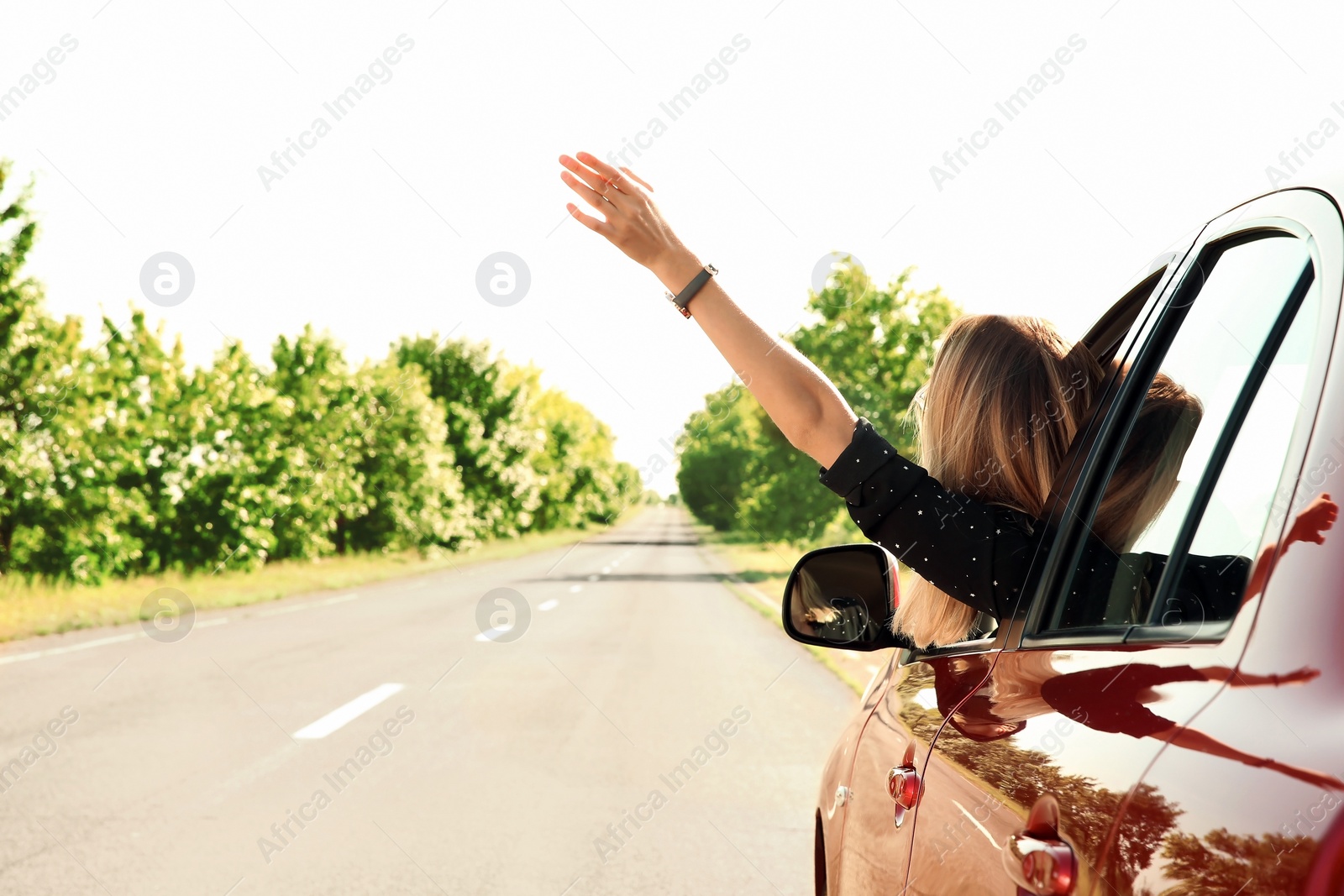 Photo of Young woman leaning out of car window