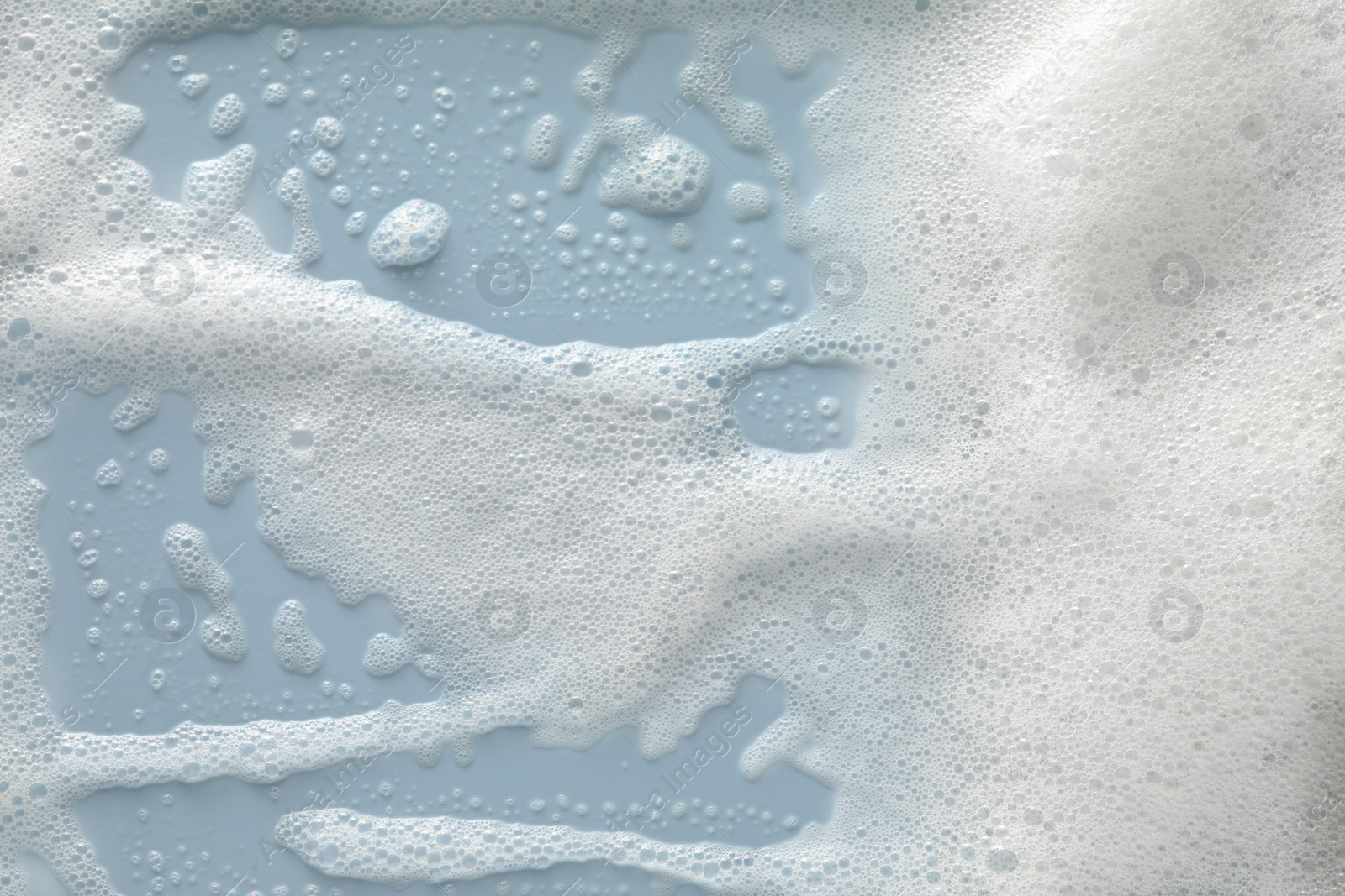 Photo of White washing foam on color background, top view