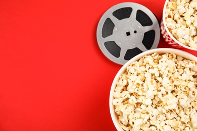 Flat lay composition with popcorn and film reel on color background