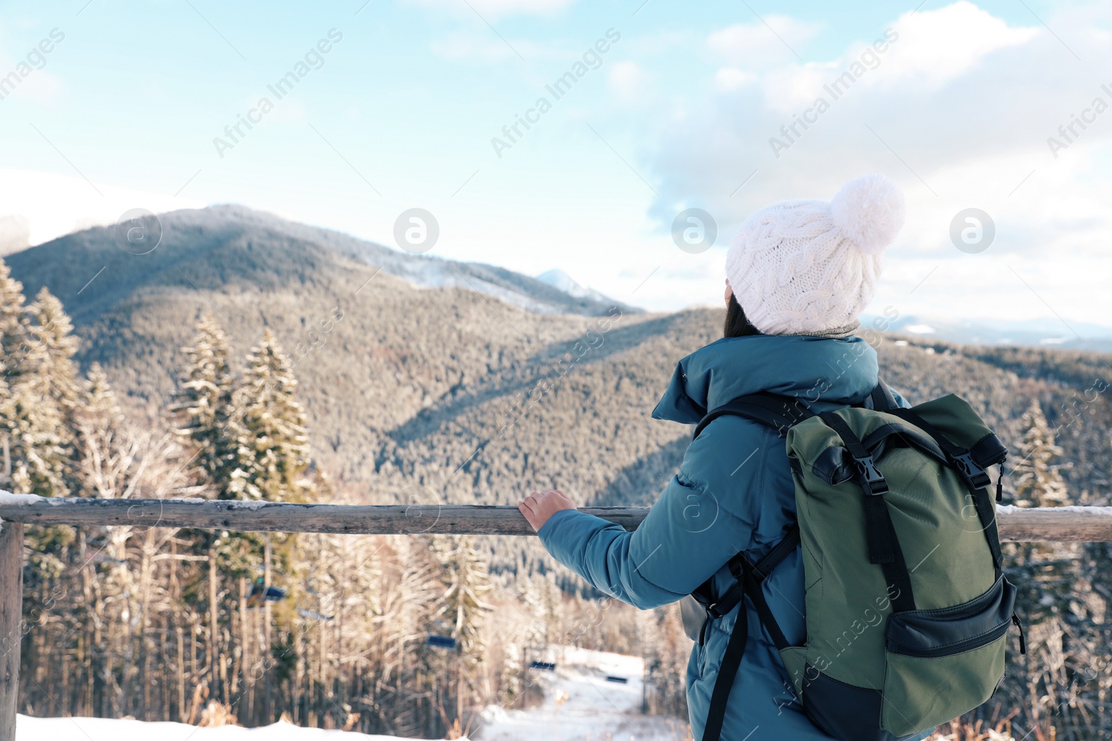 Photo of Woman with backpack enjoying mountain view during winter vacation. Space for text