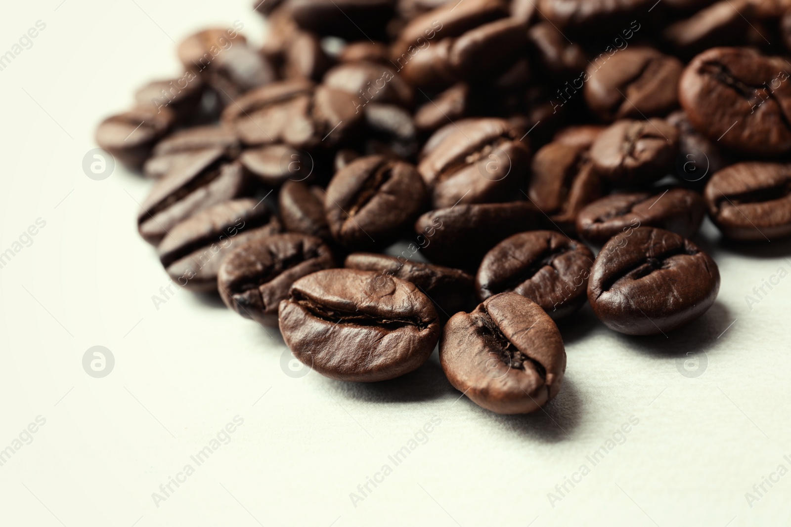 Photo of Roasted coffee beans on white background, closeup