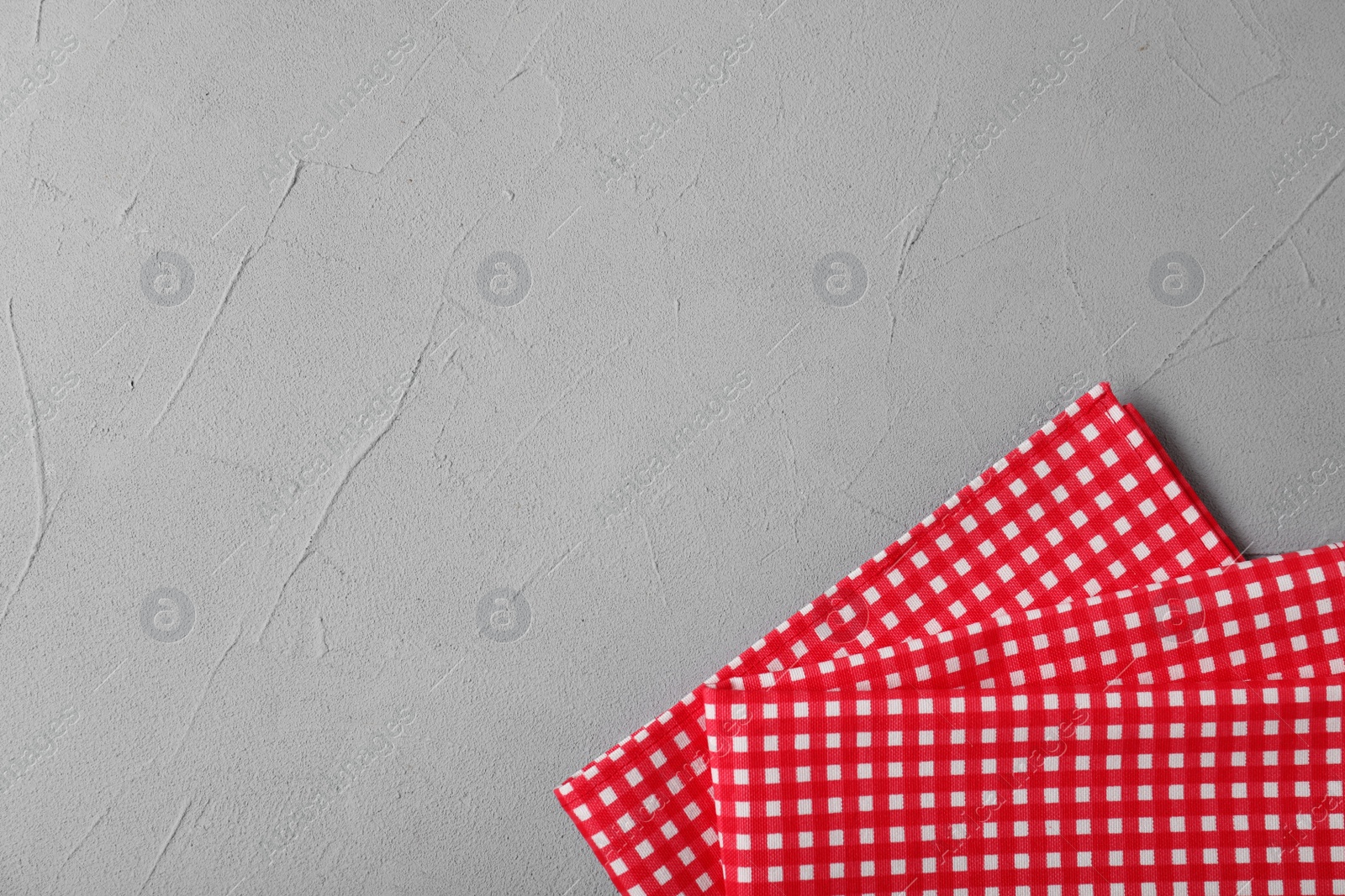 Photo of Checkered picnic napkins on color background, top view. Space for text