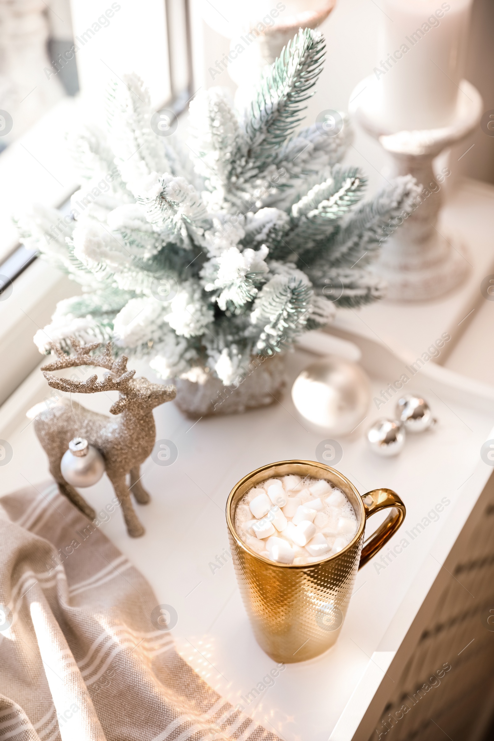 Photo of Golden cup of cocoa and Christmas decor on window sill indoors