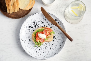 Sandwich with fresh sliced salmon fillet and avocado on plate, top view