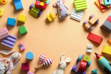 Photo of Frame made of different toys on beige background, flat lay. Space for text