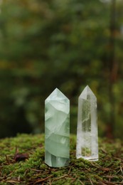 Photo of Different crystals on moss in forest, space for text