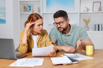 Photo of Couple doing taxes at table in room