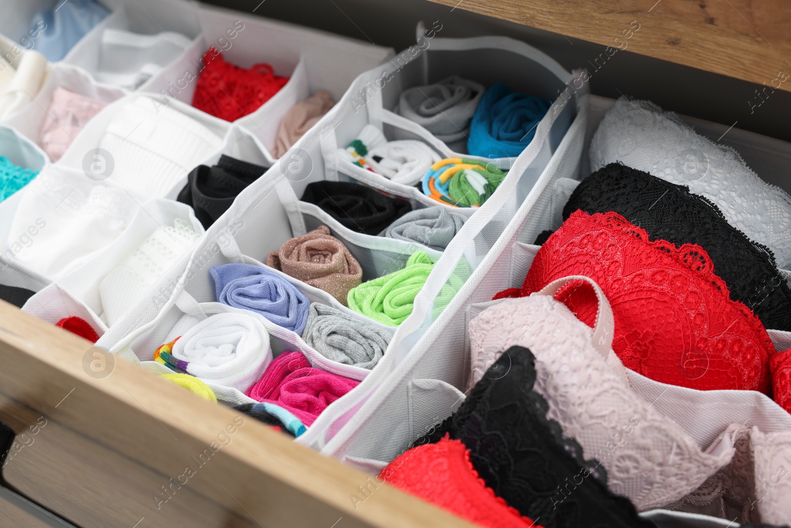 Photo of Organizers with beautiful women's underwear in drawer, closeup