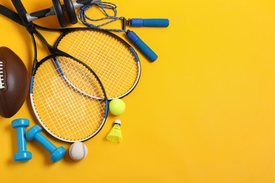Photo of Set of different sports equipment on yellow background, flat lay. Space for text