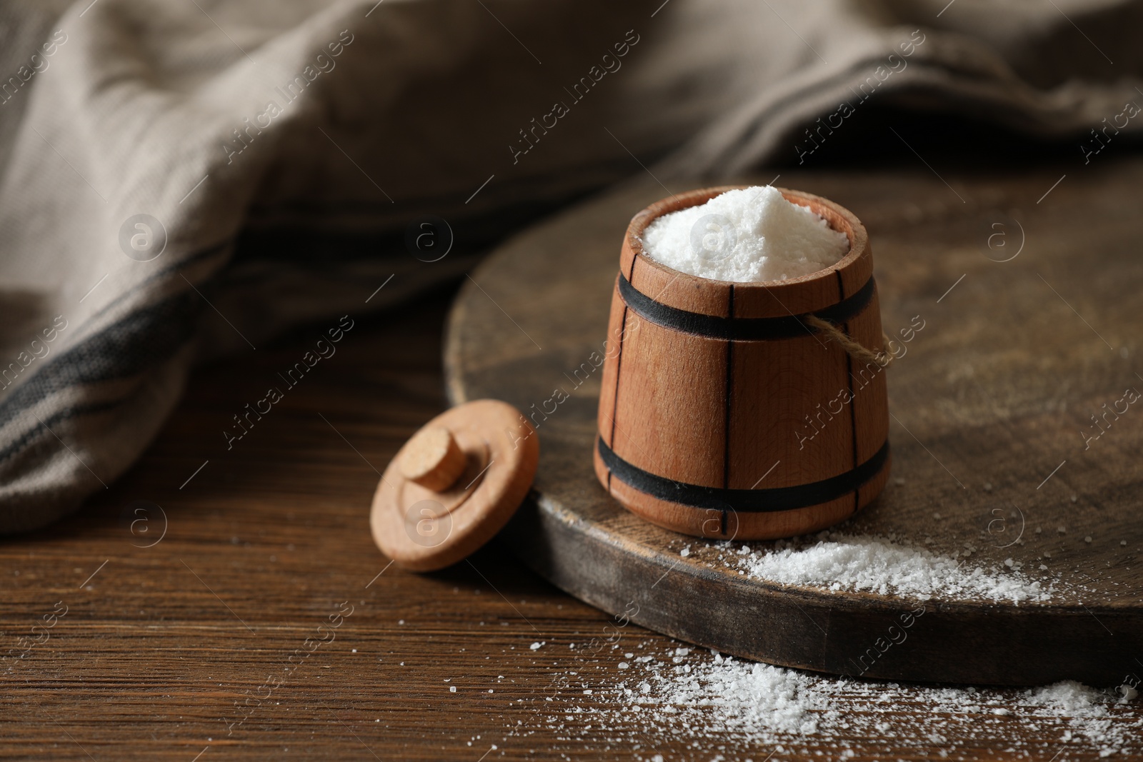 Photo of Organic salt in bowl on wooden table. Space for text