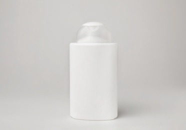 Bottle of cosmetic product on light background